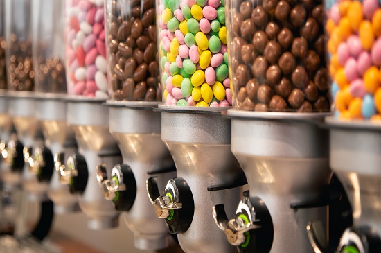 Transparent containers with multi-colored sweets and candy in the store, confectionery, selective focus.